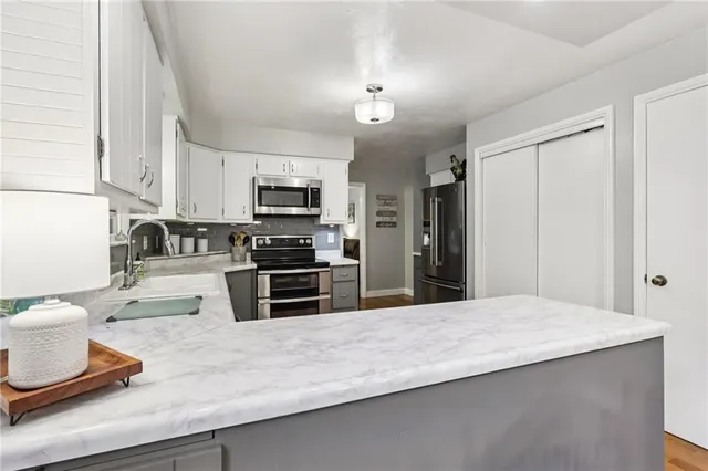 a kitchen with kitchen island a sink stainless steel appliances and cabinets