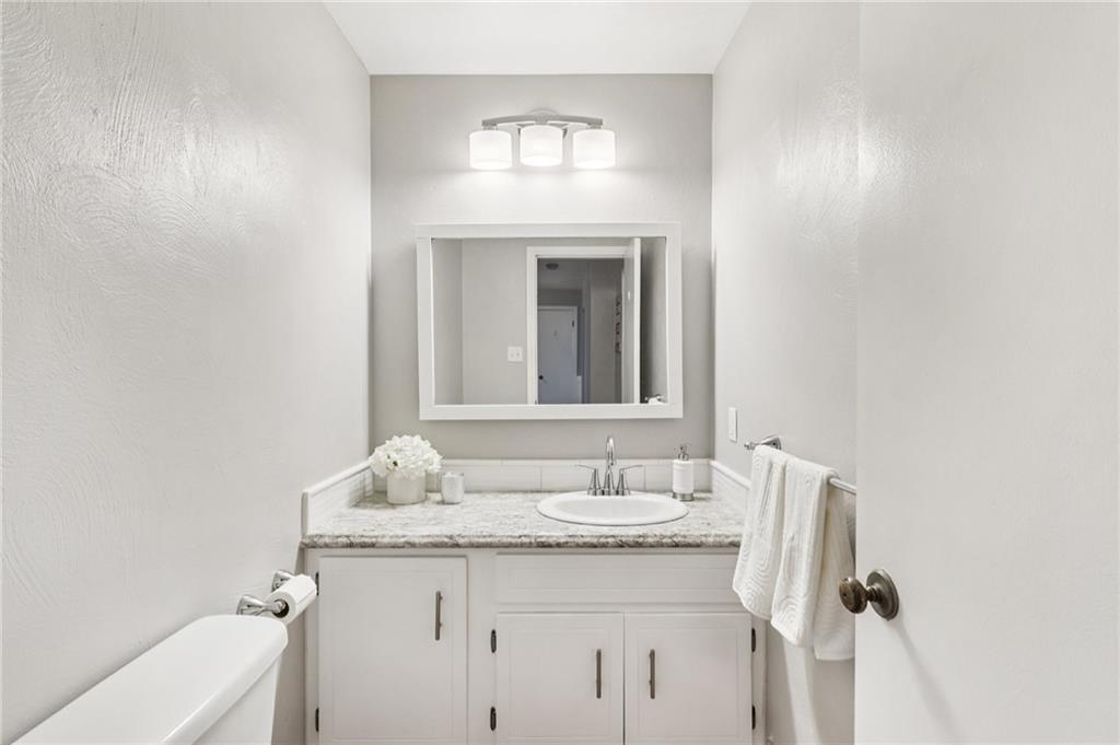 748 Four Mile Run Road Ligonier, PA 15658 - Photo 31 of 49 a bathroom with a granite countertop sink a toilet and a mirror