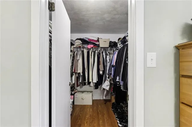 a view of walk in closet with clothes and shoes