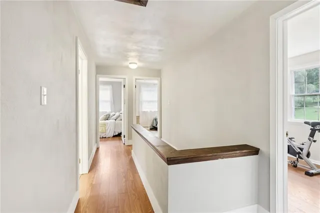 a hallway with white cabinets and wooden floor