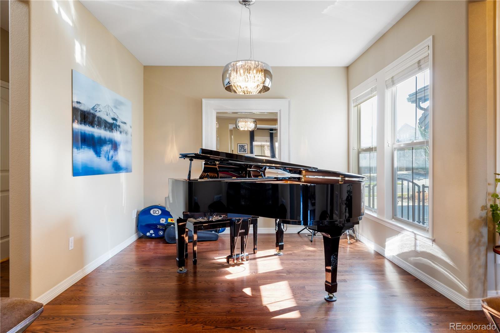 10681 Sundial Rim Road Highlands Ranch, CO 80126 - Photo 11 of 45 a dining room with wooden floor a chandelier a glass table and chairs