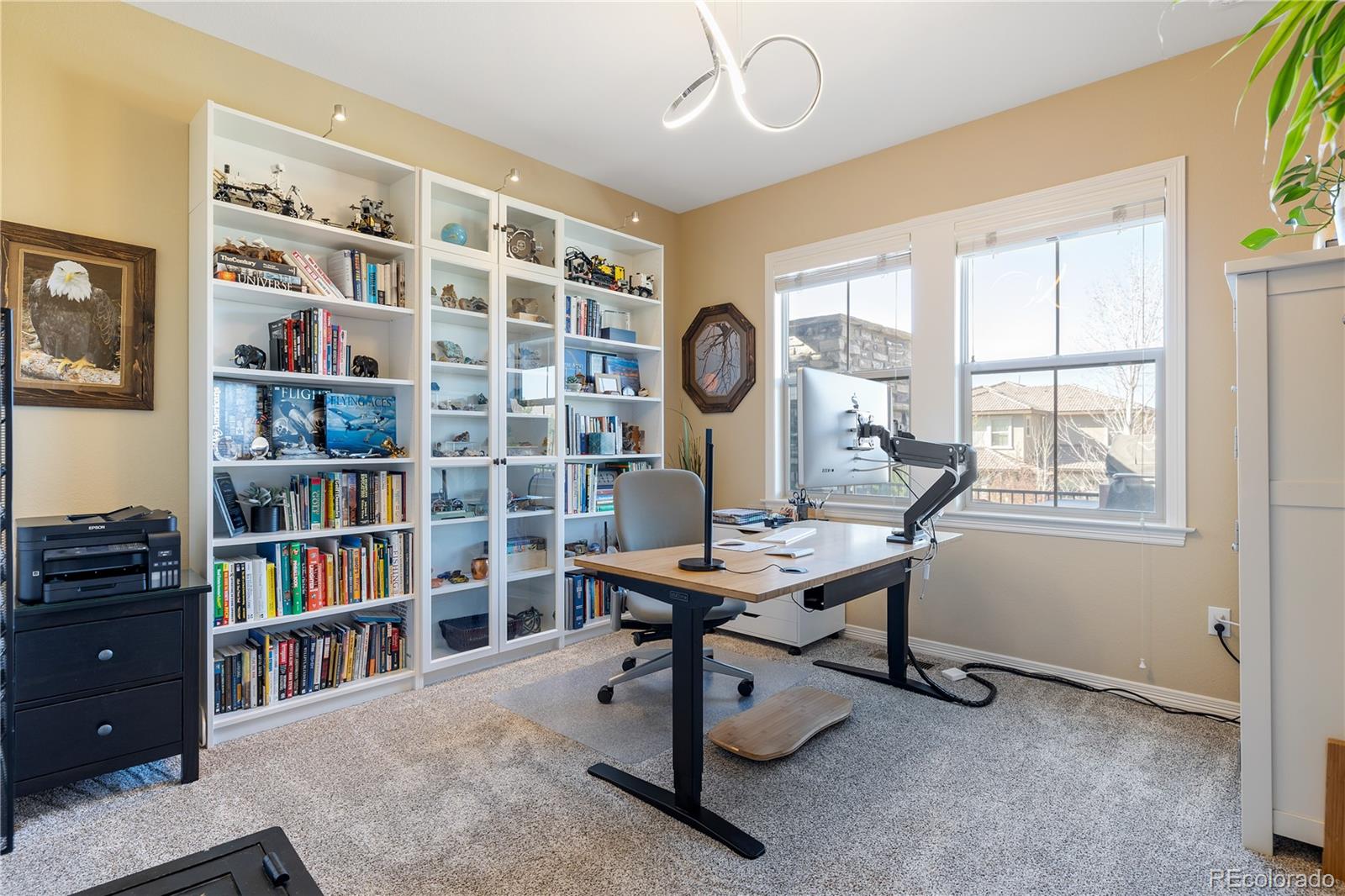 10681 Sundial Rim Road Highlands Ranch, CO 80126 - Photo 13 of 45 a view of a workspace with furniture and a bookshelf