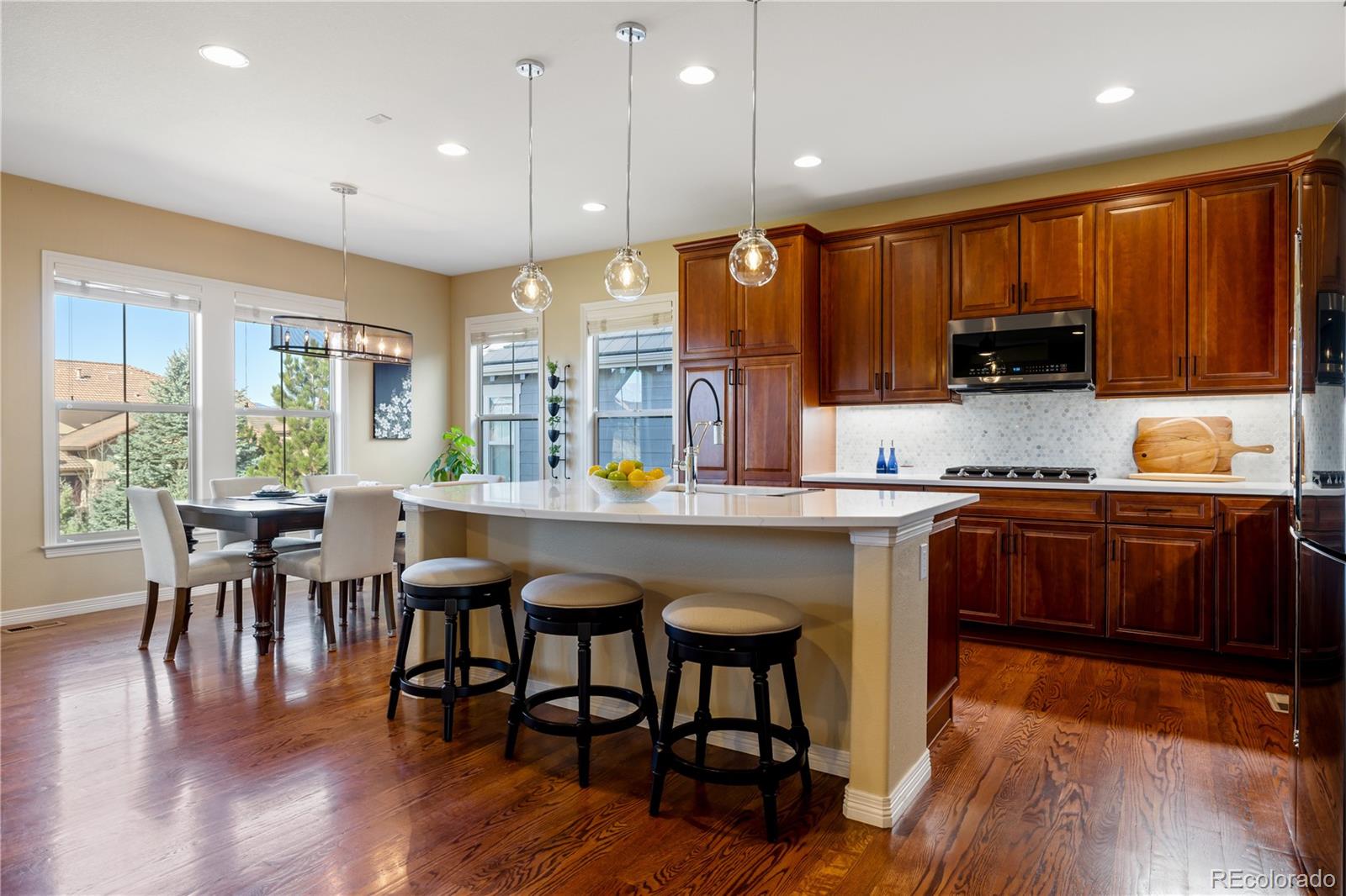 10681 Sundial Rim Road Highlands Ranch, CO 80126 - Photo 6 of 45 a kitchen with a table chairs sink and cabinets