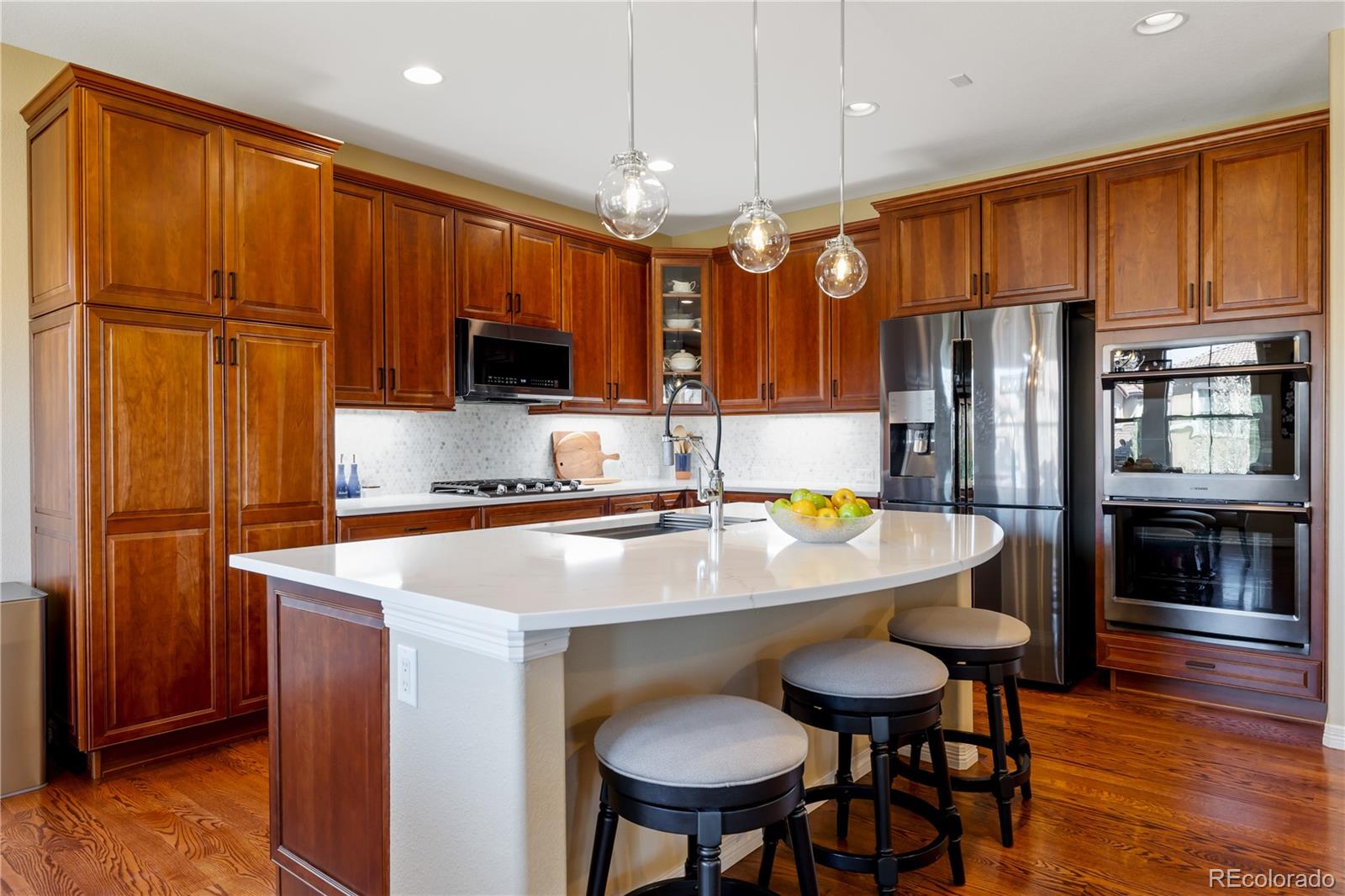 10681 Sundial Rim Road Highlands Ranch, CO 80126 - Photo 7 of 45 a kitchen with stainless steel appliances wooden floor dining table and chairs