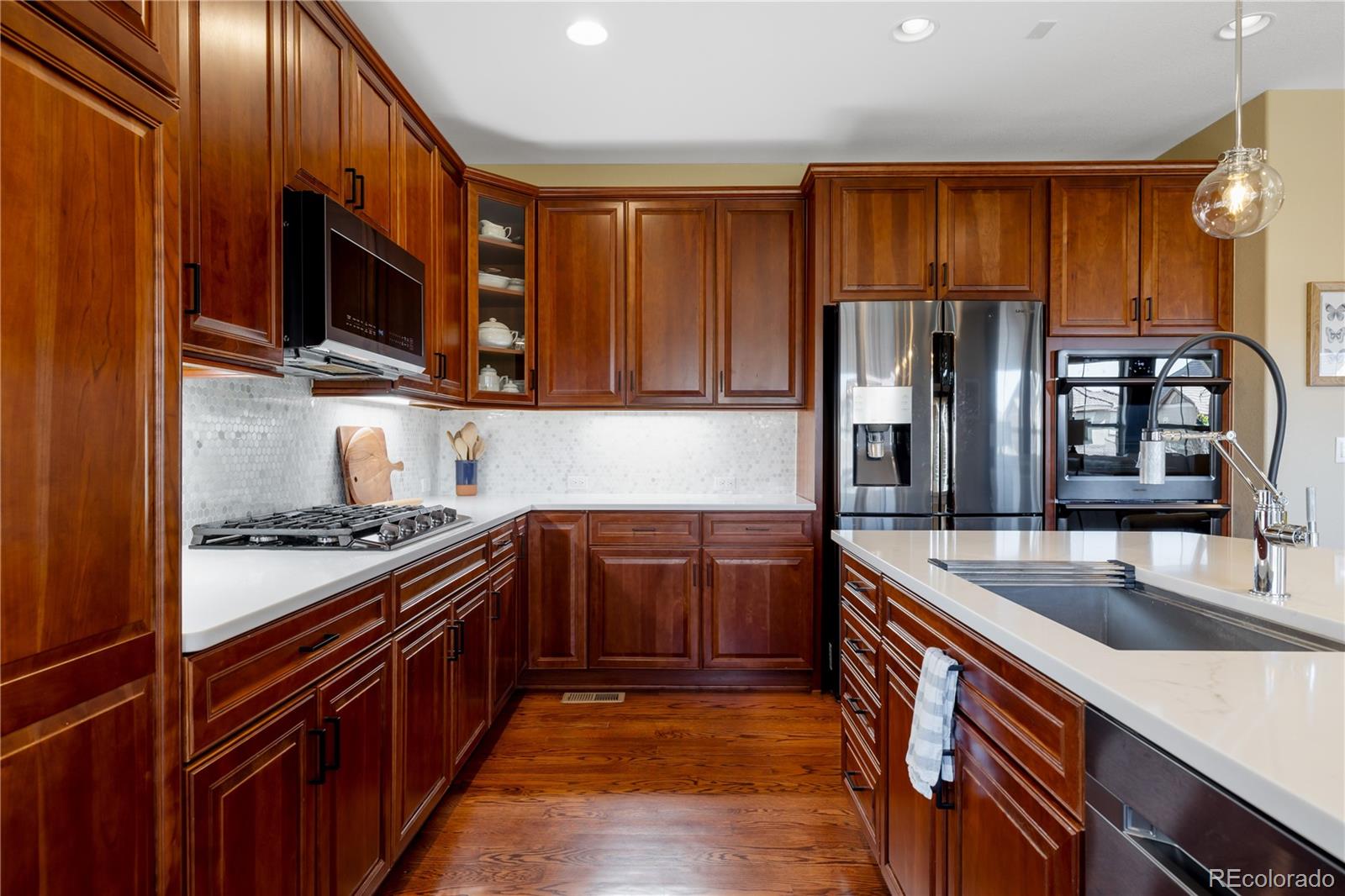 10681 Sundial Rim Road Highlands Ranch, CO 80126 - Photo 8 of 45 a kitchen with stainless steel appliances granite countertop a stove and a sink