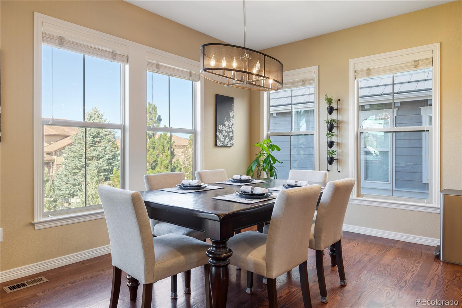 10681 Sundial Rim Road Highlands Ranch, CO 80126 - Photo 9 of 45 a dining room with furniture a chandelier and wooden floor