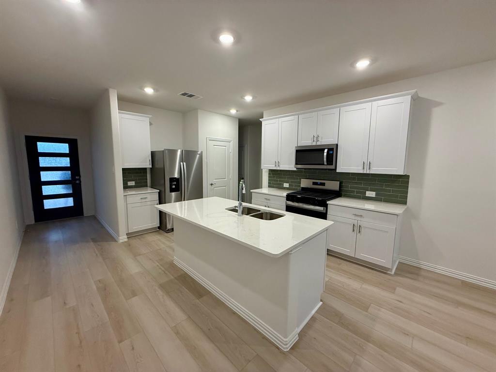 1733 Arches Road Anna, TX 75409 - Photo 3 of 17 a kitchen with a sink stainless steel appliances and cabinets
