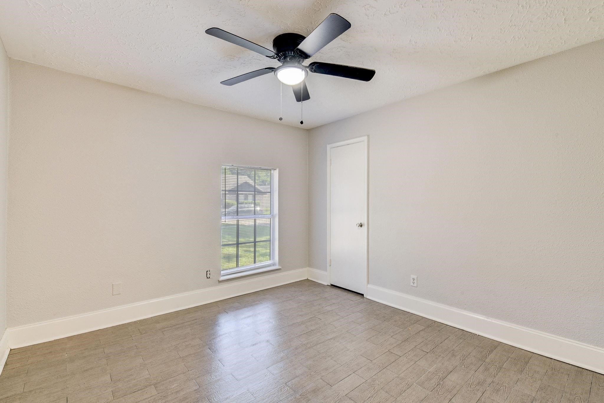 18015 Woodgum Drive Spring, TX 77388 - Photo 17 of 23 an empty room with ceiling fan and windows