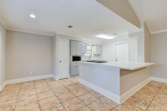 a large white kitchen with a sink and cabinets