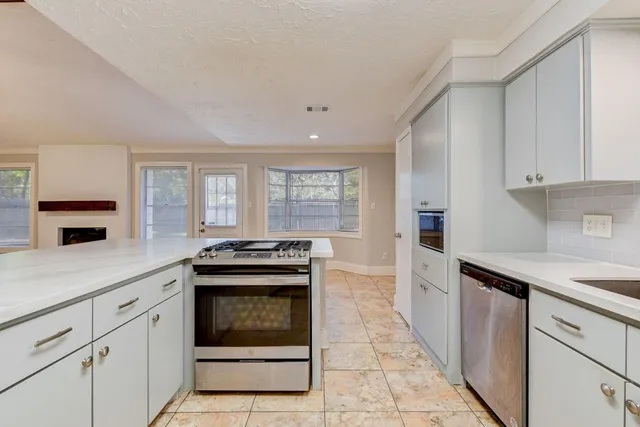 a kitchen with granite countertop a stove sink and cabinets