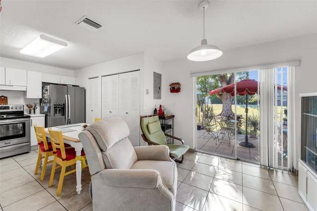 a living room with furniture a dining table and a refrigerator