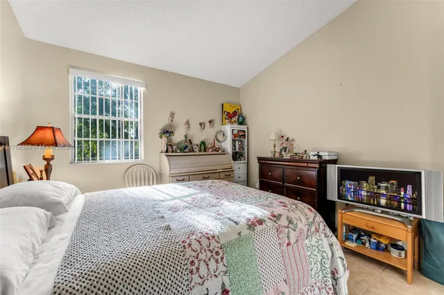 a bedroom with a bed and a dresser next to a window
