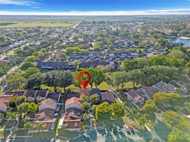 an aerial view of residential houses with outdoor space and ocean view