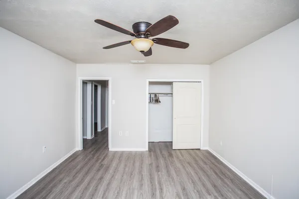 an empty room to closet and wooden floor