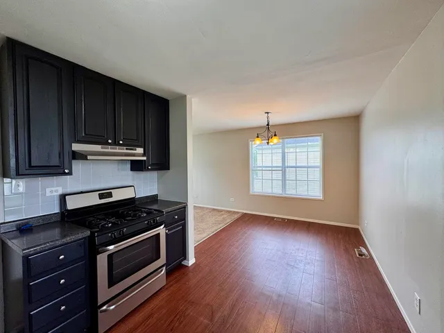a kitchen with wooden floors and black appliances