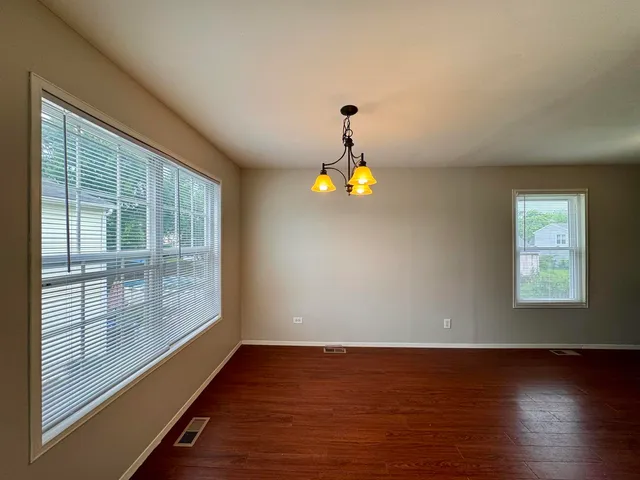 a view of wooden floor and windows in a room