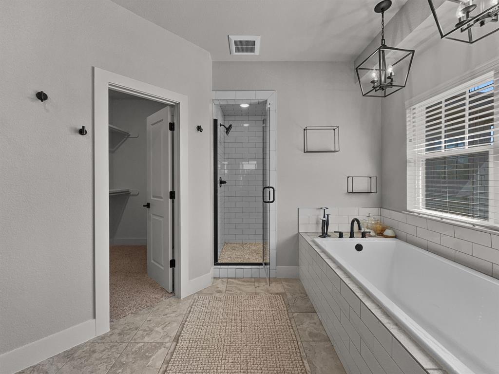 1044 Chapel Ridge Road Graford, TX 76449 - Photo 22 of 34 a spacious bathroom with a tub shower and mirror