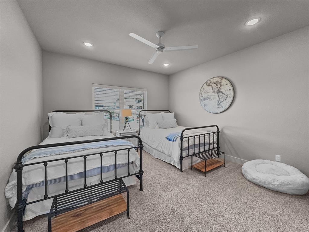 1044 Chapel Ridge Road Graford, TX 76449 - Photo 23 of 34 a spacious bedroom with a bed a window and a chandelier