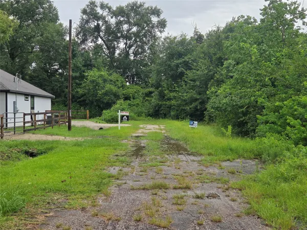 a street sign sitting on a wall next to a white wall