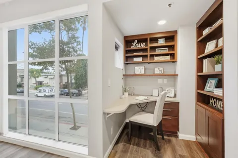 a view of a workspace with furniture and a window