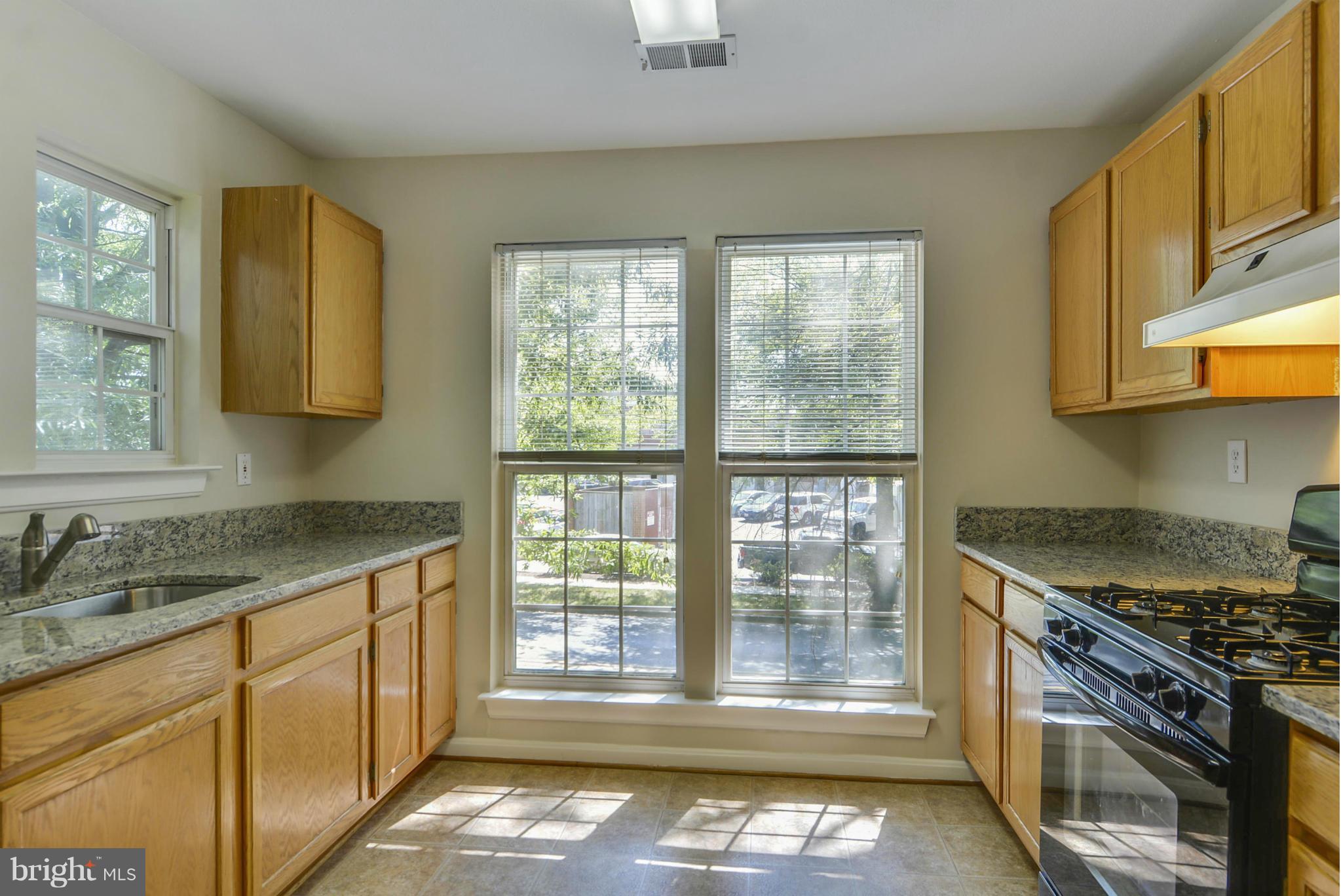 110 Booth Street, Unit 28 Gaithersburg, MD 20878 - Photo 3 of 30 a kitchen with granite countertop a stove a sink and a granite counter tops