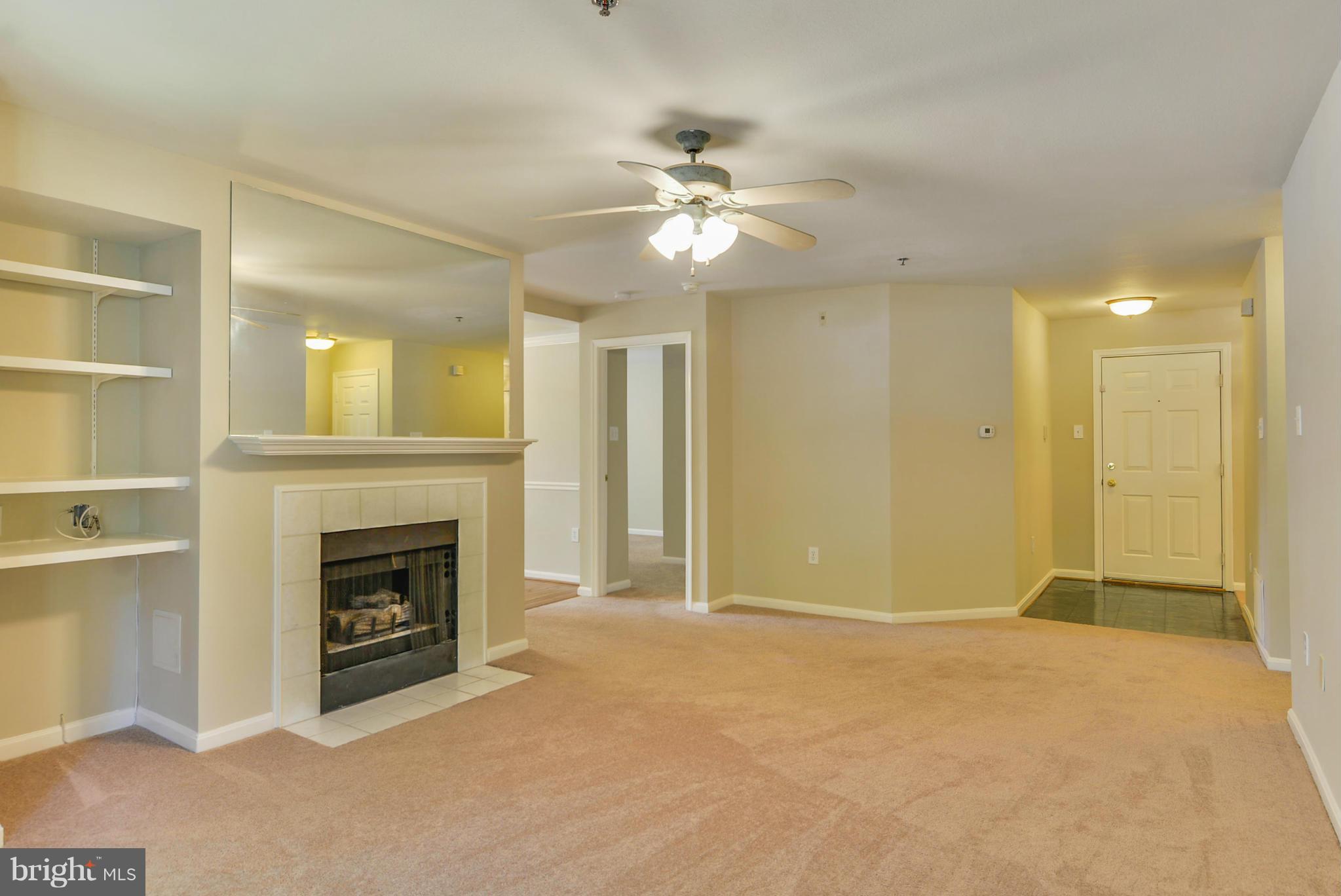 110 Booth Street, Unit 28 Gaithersburg, MD 20878 - Photo 5 of 30 a view of an empty room with chandelier fan and fire place