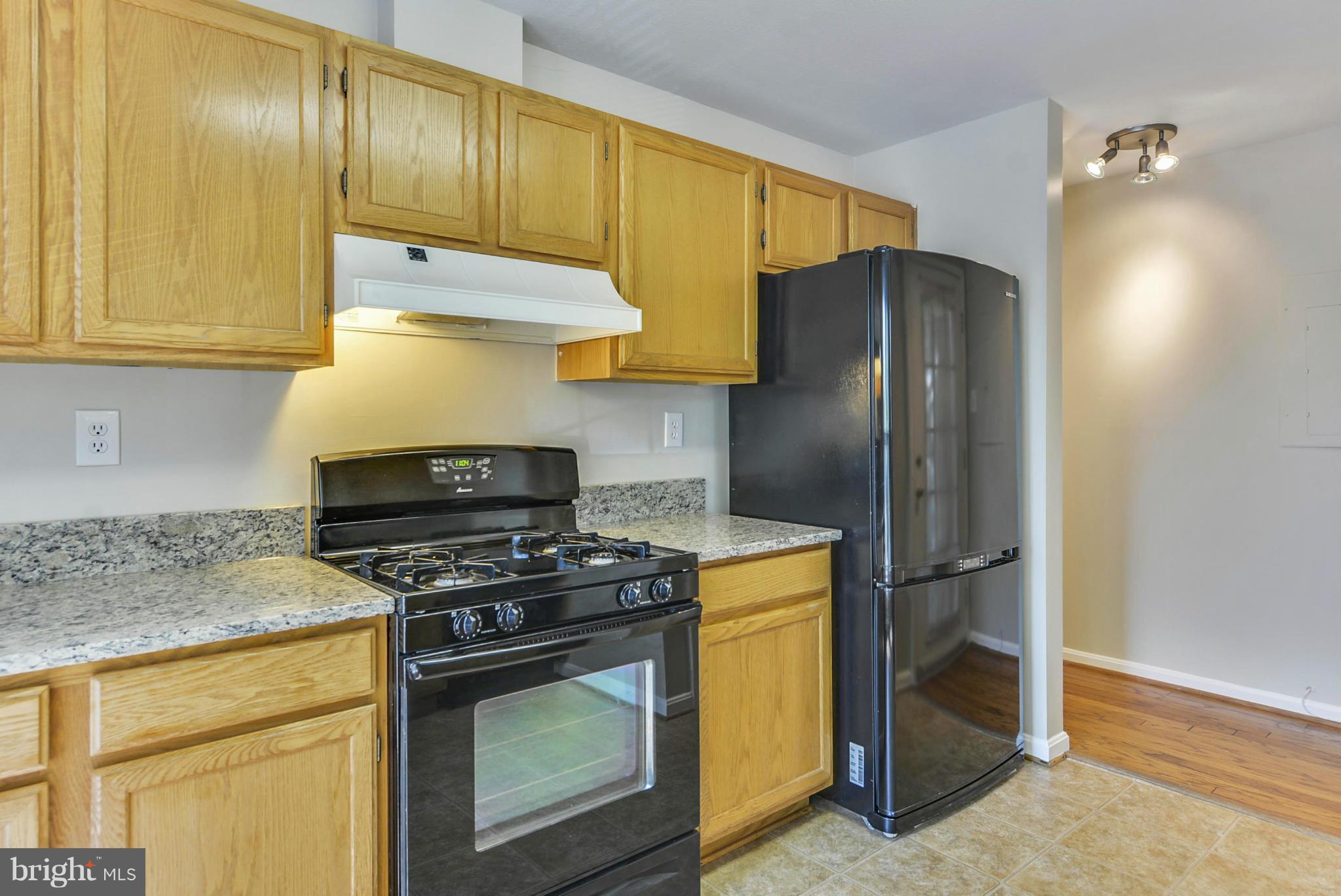 110 Booth Street, Unit 28 Gaithersburg, MD 20878 - Photo 6 of 30 a kitchen with stainless steel appliances granite countertop a refrigerator and a stove top oven