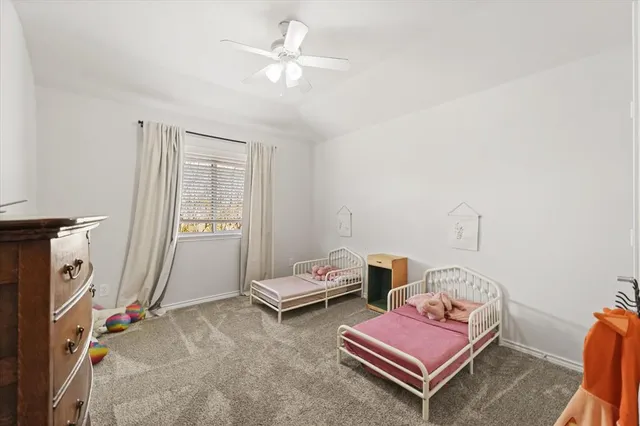 a bedroom with furniture and a chandelier fan