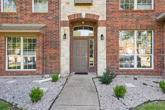 a front view of a house with a yard and potted plants