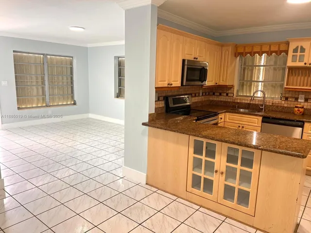 a kitchen with granite countertop a stove a sink and a microwave