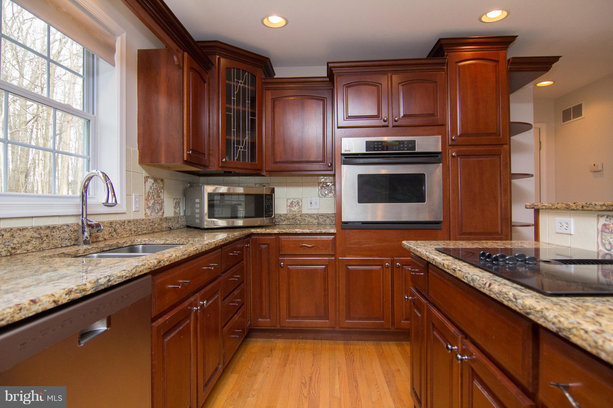 15825 Yeoho Road Sparks, MD 21152 - Photo 2 of 30 a kitchen with stainless steel appliances granite countertop wooden cabinets and a stove top oven