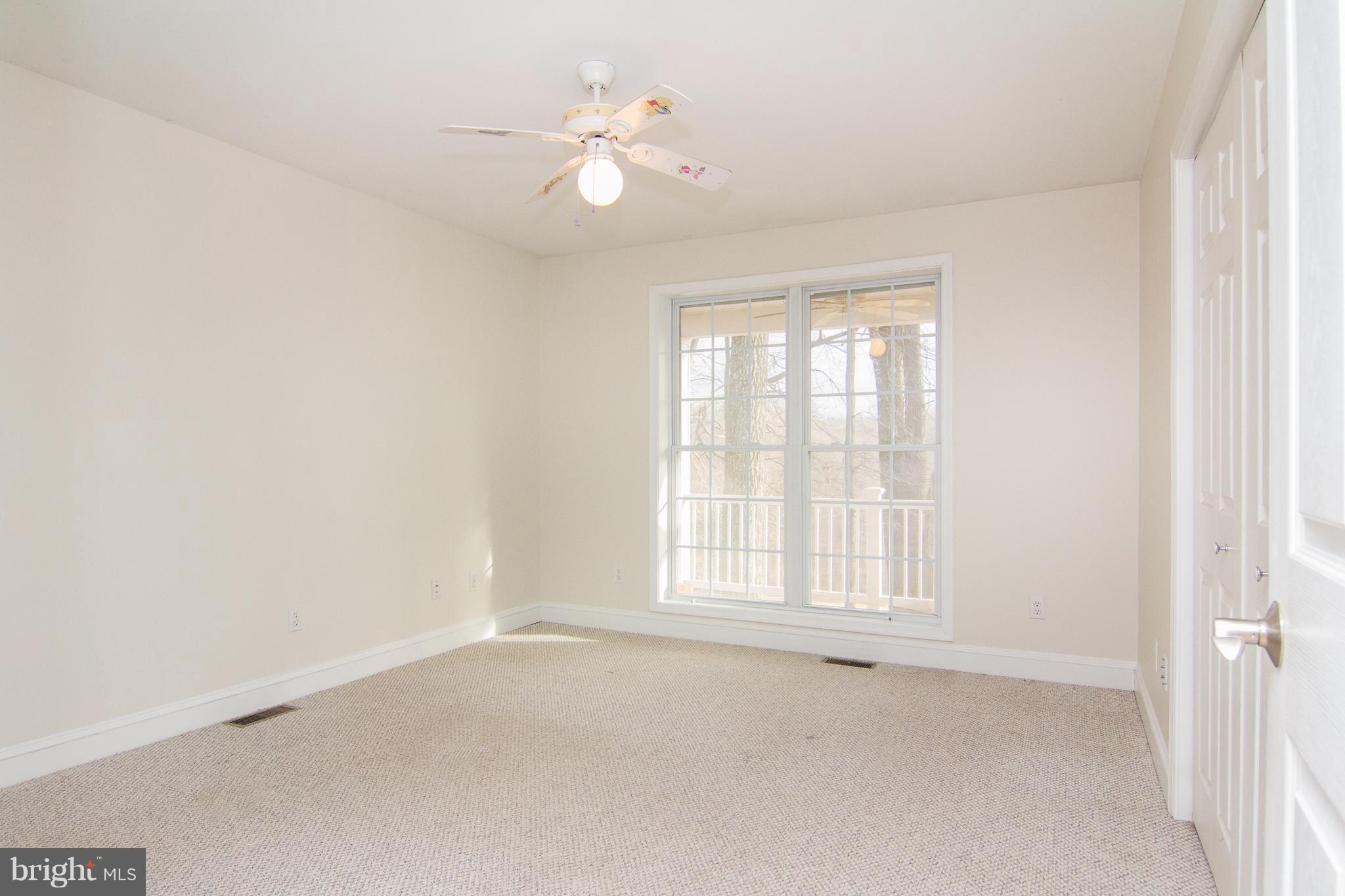 15825 Yeoho Road Sparks, MD 21152 - Photo 13 of 30 an empty room with windows and ceiling fan