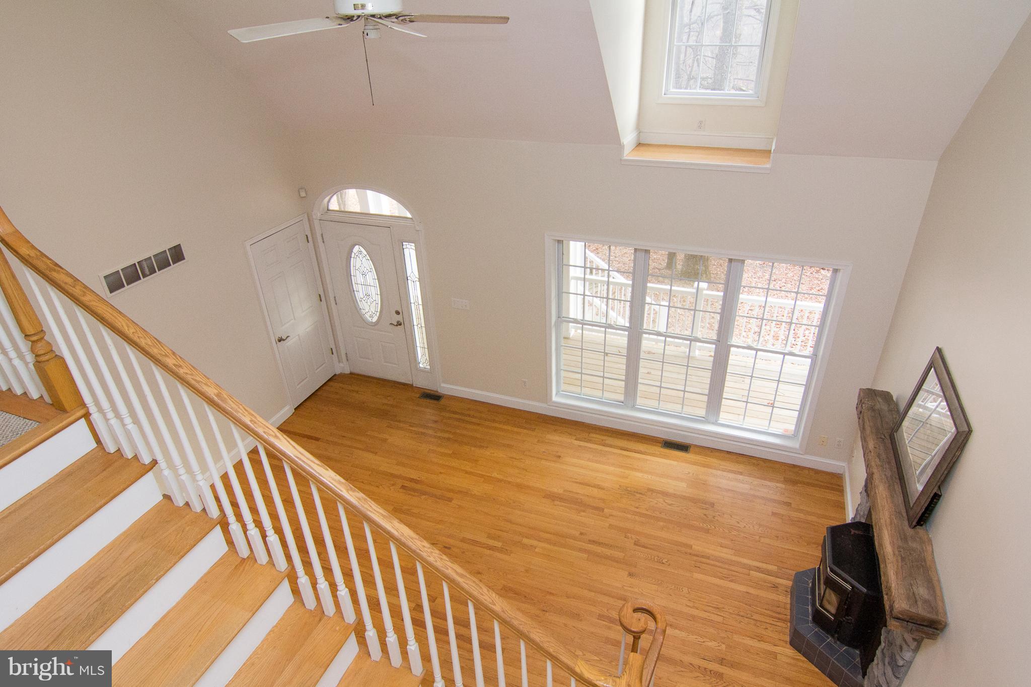 15825 Yeoho Road Sparks, MD 21152 - Photo 6 of 30 a view of an empty room with chandelier fan and wooden floor
