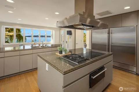 a kitchen with stainless steel appliances granite countertop a sink and a refrigerator