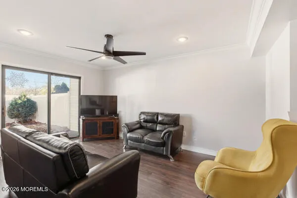 a living room with furniture a ceiling fan and a window