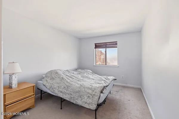 a bedroom with a bed and a lamp on desk