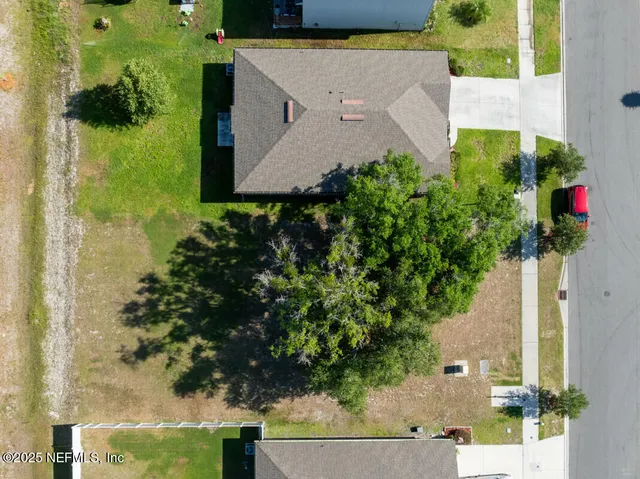an aerial view of a house with a yard basket ball court and outdoor seating