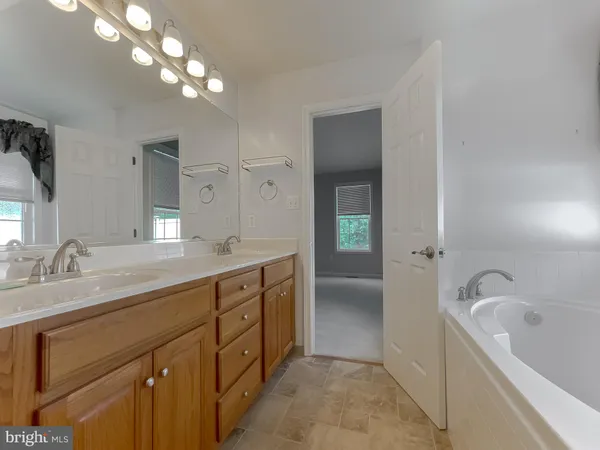 a kitchen with stainless steel appliances granite countertop a refrigerator a sink dishwasher a stove and a large window with wooden floor