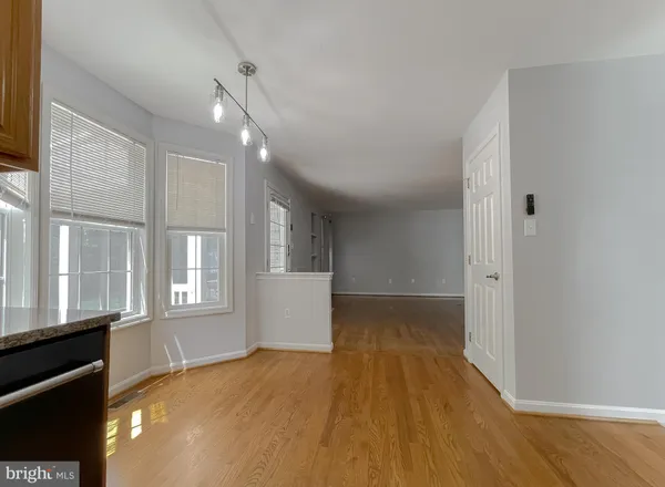 an empty room with chandelier fan and windows