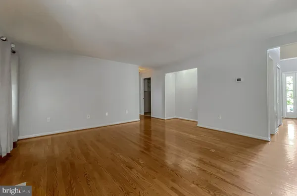 a view of an empty room with a chandelier fan