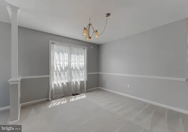 a view of an empty room with closet and a window