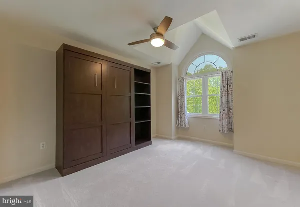 a view of a room with a wooden ceiling fan
