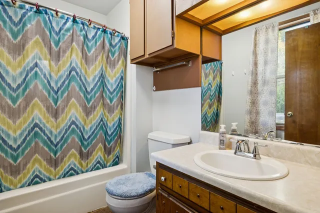 a bathroom with a sink a toilet and a mirror