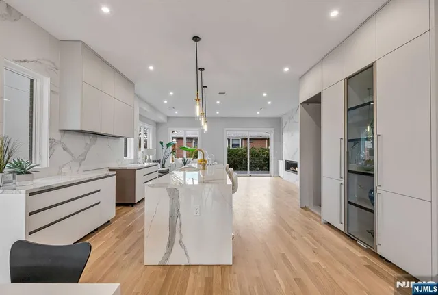 a large white kitchen with lots of counter space wooden floor and appliances