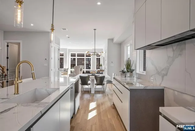 a large kitchen with kitchen island a large counter top space a sink stainless steel appliances and cabinets