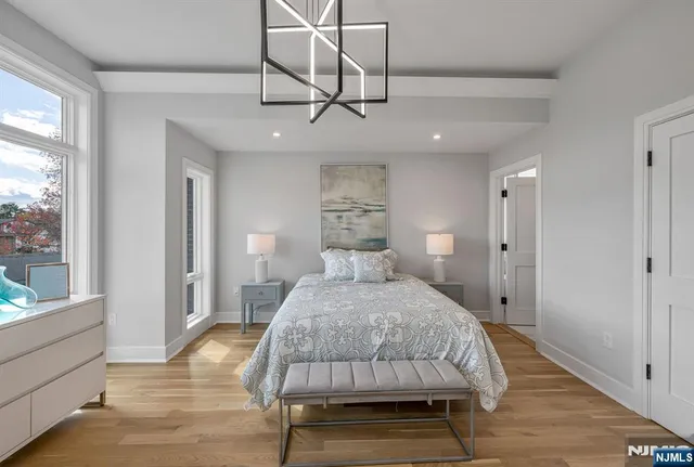 a bedroom with a bed mirror and window