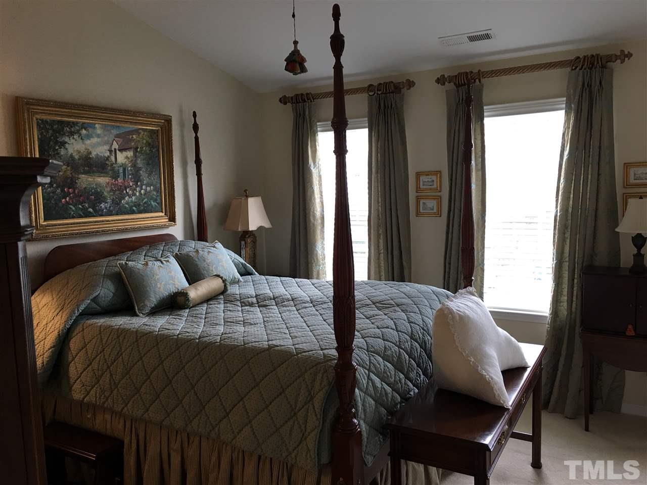 7634 Winners Edge Street Raleigh, NC 27617 - Photo 16 of 22 a bedroom with a bed and glass window
