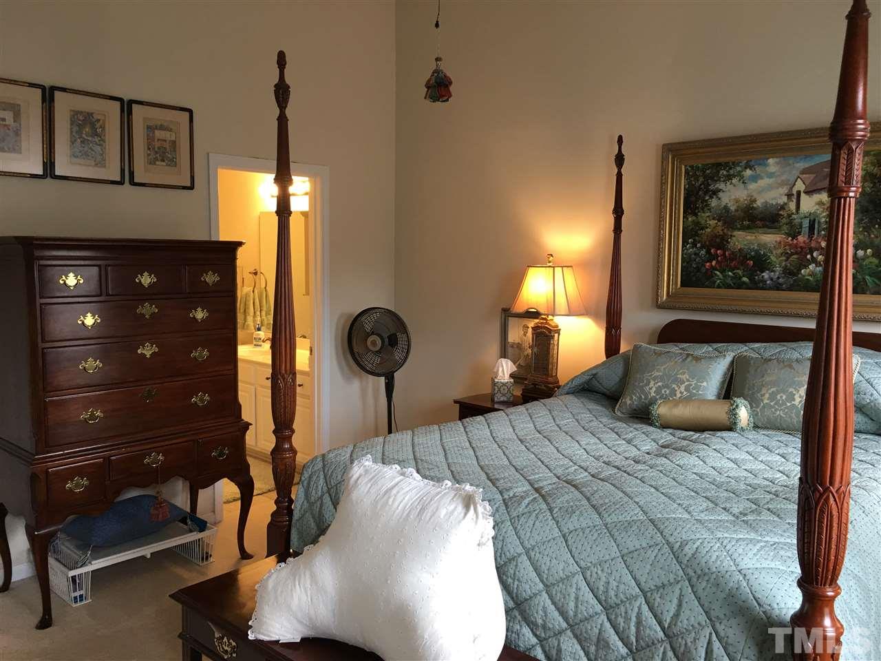 7634 Winners Edge Street Raleigh, NC 27617 - Photo 18 of 22 a bedroom with a bed and a night stand