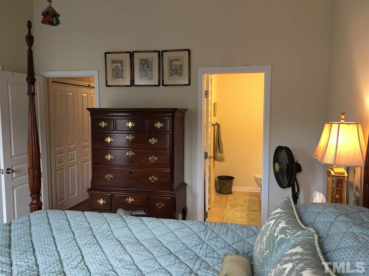 7634 Winners Edge Street Raleigh, NC 27617 - Photo 19 of 22 a bedroom with a bed and a dresser