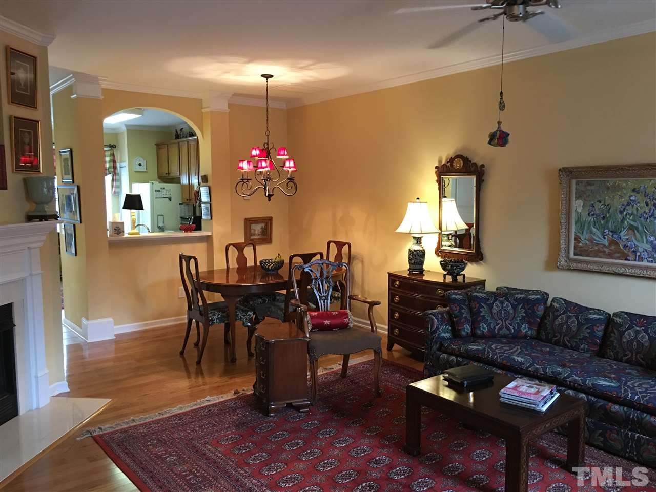 7634 Winners Edge Street Raleigh, NC 27617 - Photo 4 of 22 a living room with furniture a dining table and a fireplace